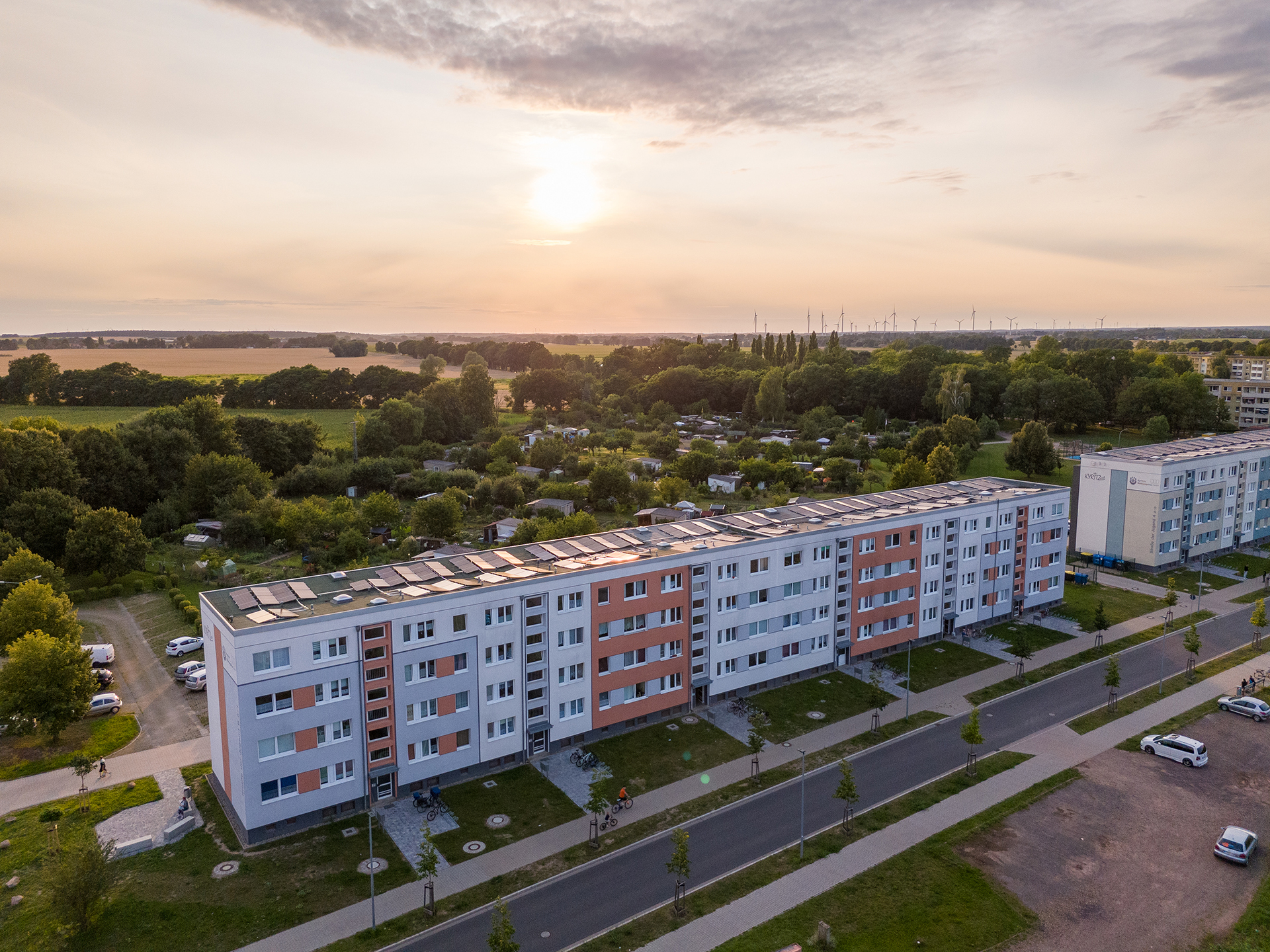 Ein Häuserblock in Abendstimmung mit Solarzellen auf den Dächern.